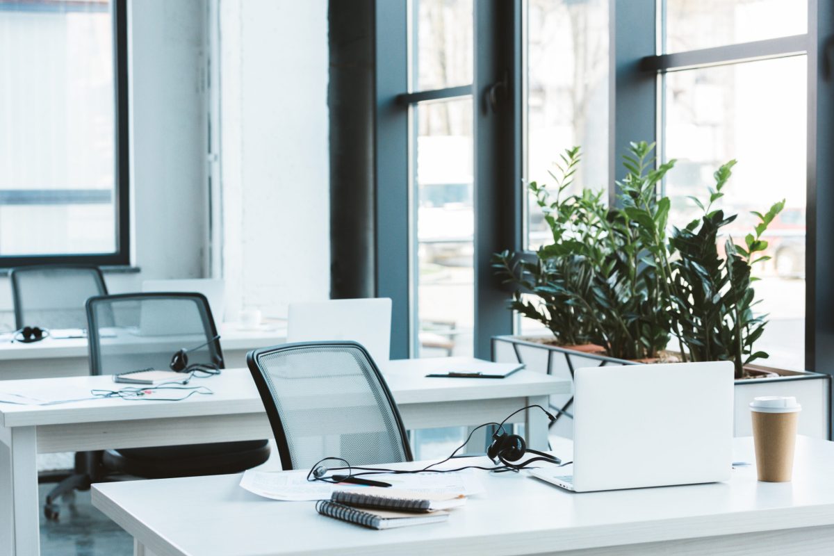 Heller und moderner Großraumbüro-Arbeitsplatz mit Schreibtischen, Laptops und Headsets, professionell gepflegt von A&S Service Hannover.